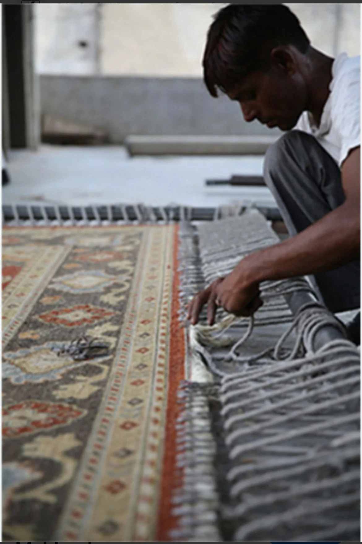Weaver hand-knotting an Oriental rug on a loom